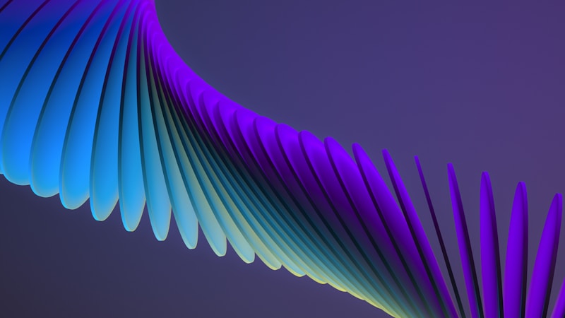 A laptop closed on a desk next to a paper notebook and pen